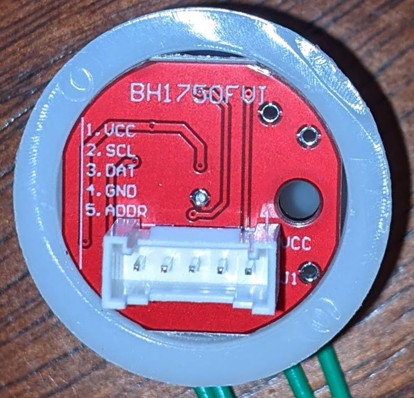 Back of the BH1750FVI light sensor, showing the silk-screened labels.  About 1 inch in diameter.