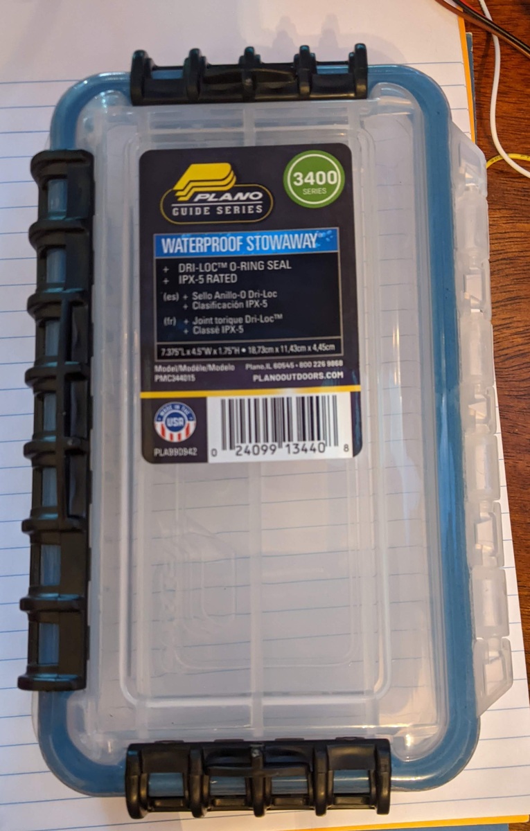 A clear plastic Plano Waterproof Stowaway box with orange latches.