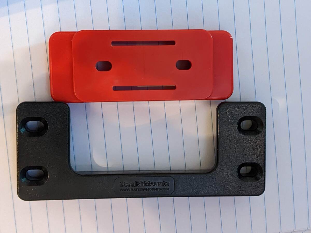 A black plastic Stealthmounts cleat and foot, used for mounting the sensor enclosure.